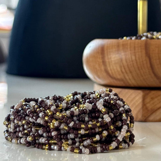 Earth & Ether waist beads for women, handcrafted with warm brown, soft lilac, and gold glass beads. Translucent lilac accents blend with earthy tones, symbolising balance, intuition, and feminine energy. Adjustable waist beads designed for self-love, spiritual growth, and grounded confidence.
