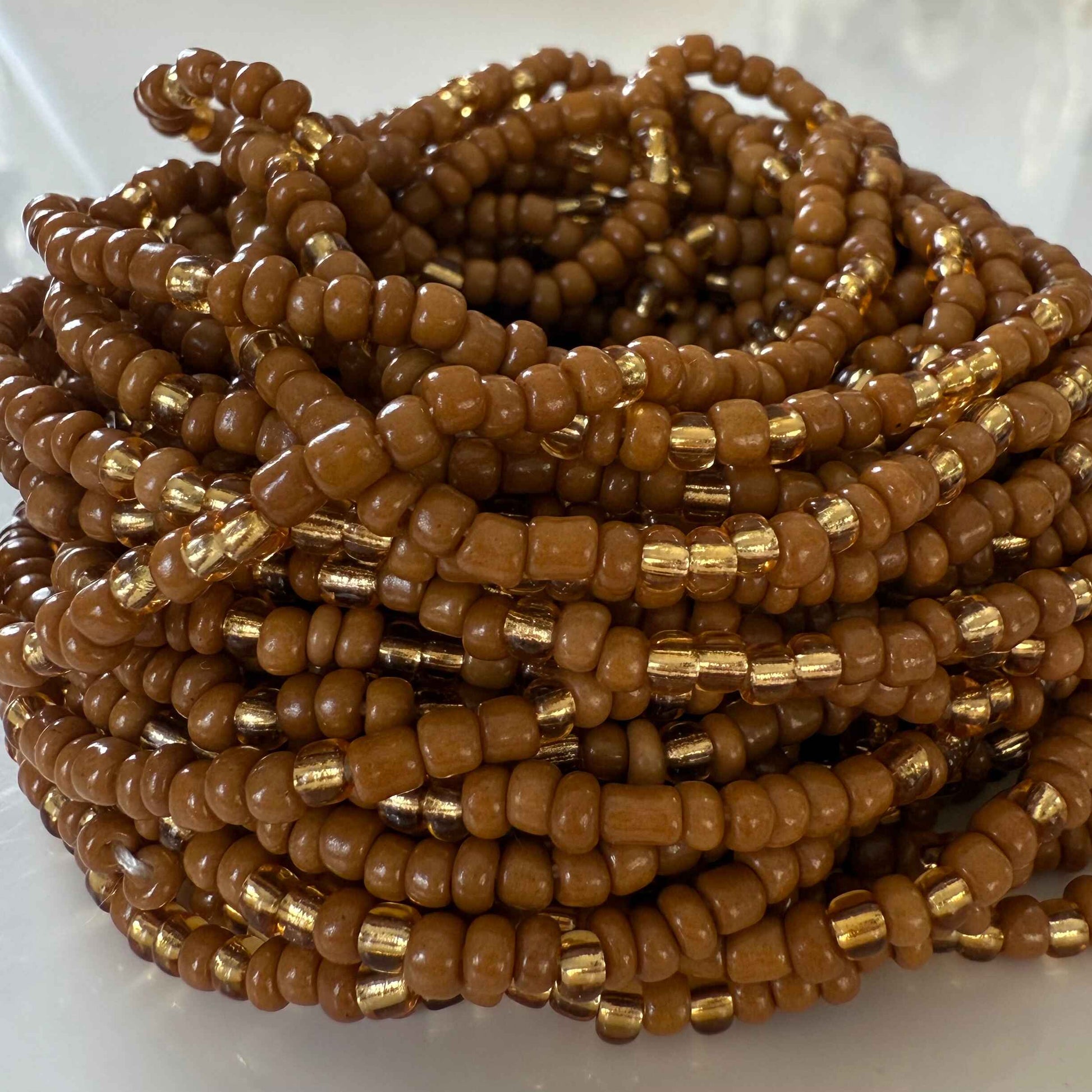 Brown Sugar Aura handmade waist beads with caramel brown and light gold glass beads, representing self-love, body positivity, and divine feminine energy. African-inspired waist jewelry for women embracing softness, sensuality, and intentional adornment.