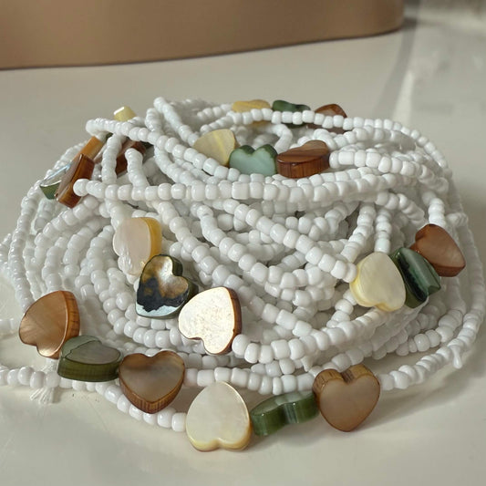 White waist beads with resin heart charms, symbolising love, purity, and feminine energy. Tie-on waist beads for women, handmade and meaningful.