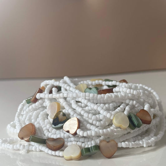 White beaded necklace with heart-shaped multicolored beads on a light background